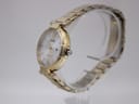 Side profile view showing the elegant gold tone watch case, crown, and integrated steel bracelet.