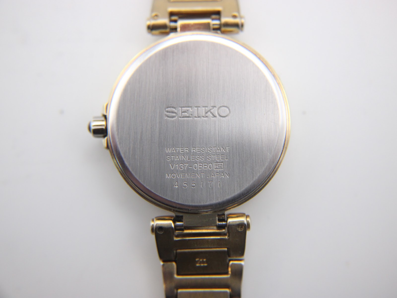 Detail of the gold tone steel bracelet and the signed Seiko folding clasp closure.