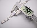 Overhead view of the Seiko watch being measured by a digital caliper, displaying a case size of 20.84mm.