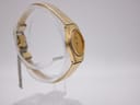 Three-quarter view of the gold Seiko watch on a display stand, showcasing the integrated mesh bracelet.