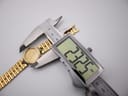 Detail of the gold-tone integrated steel link bracelet and its plain fold-over clasp.