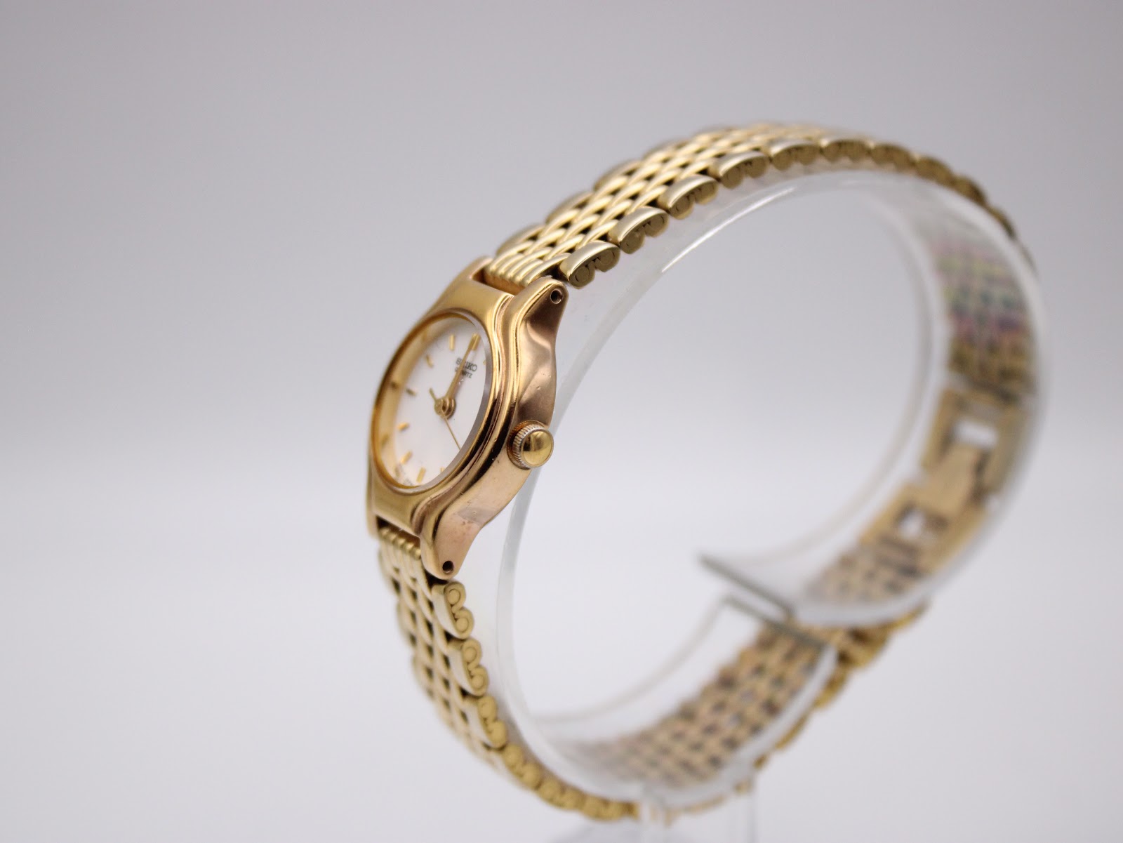 Side profile of the small gold-tone case and integrated bracelet links on the Seiko ladies' watch.