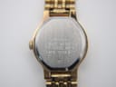 Detailed close-up of the clean white dial with slim gold-tone stick markers on a Seiko quartz watch.