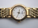 Gold-tone integrated steel bracelet of the Seiko watch, shown on a wrist sizing tool.