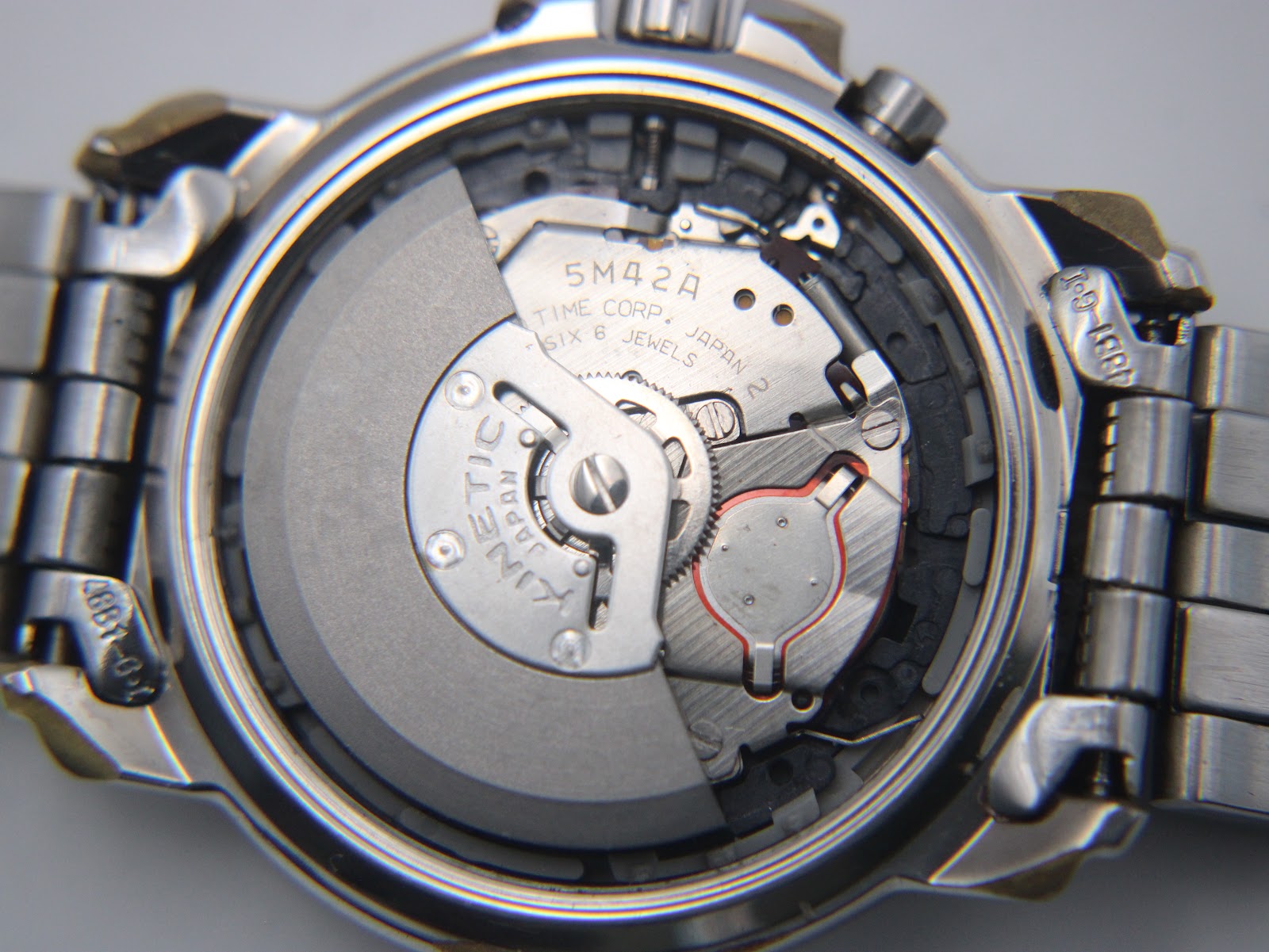 Detailed view of the Seiko 5M42A Kinetic movement inside the open case back.