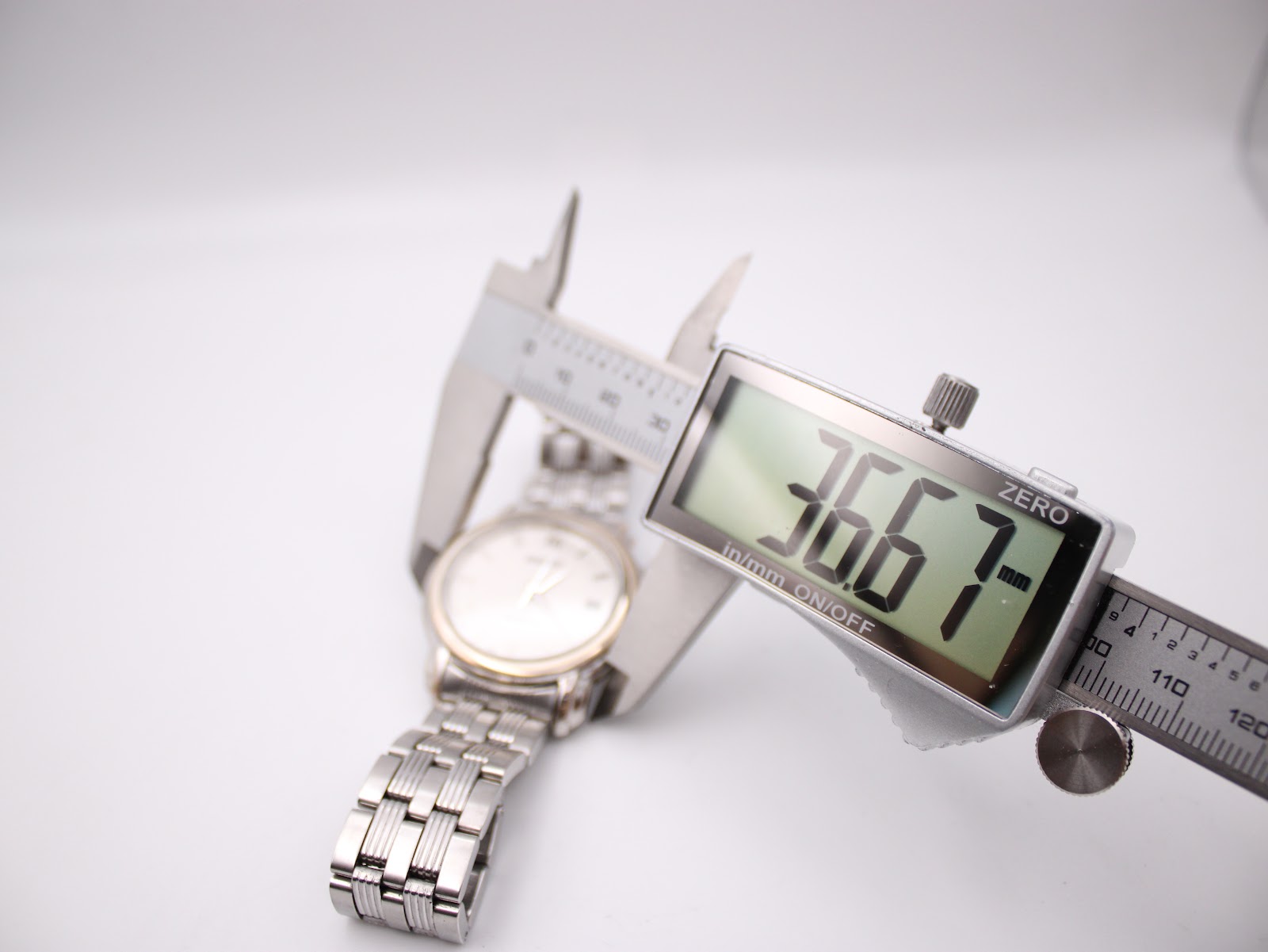 Digital caliper measuring the case diameter of the Seiko watch at 36.67mm.