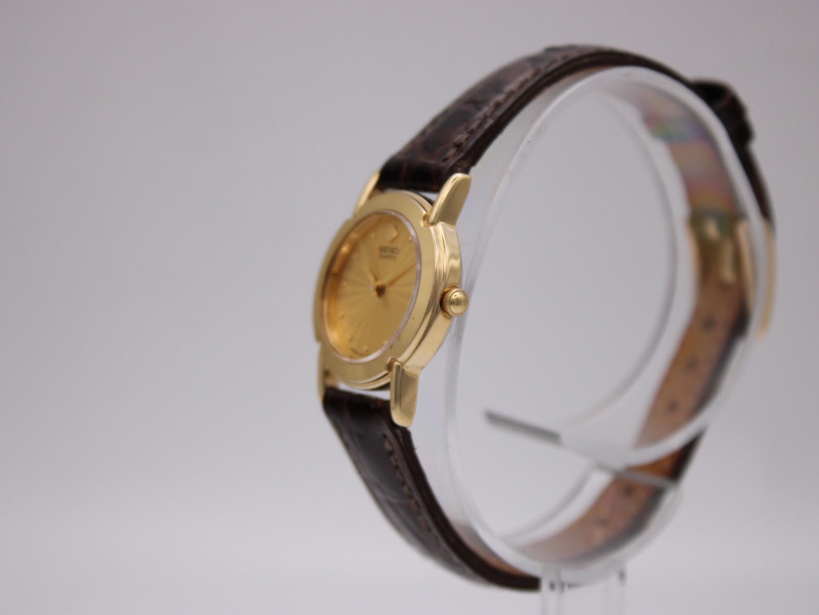 Side profile view of the gold-toned Seiko watch case and crown.
