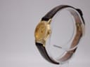Side profile view of the gold-toned Seiko watch case and crown.
