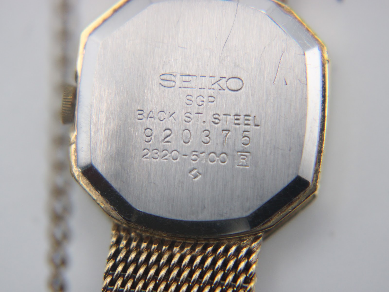 Detailed view of the Seiko watch case back with serial number and model information.