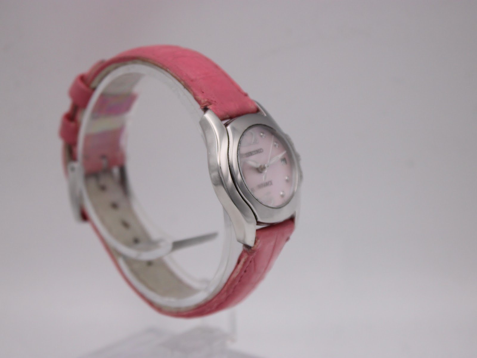 Left side profile of the Seiko Vivace quartz watch, highlighting the curved stainless steel case and pink leather strap.