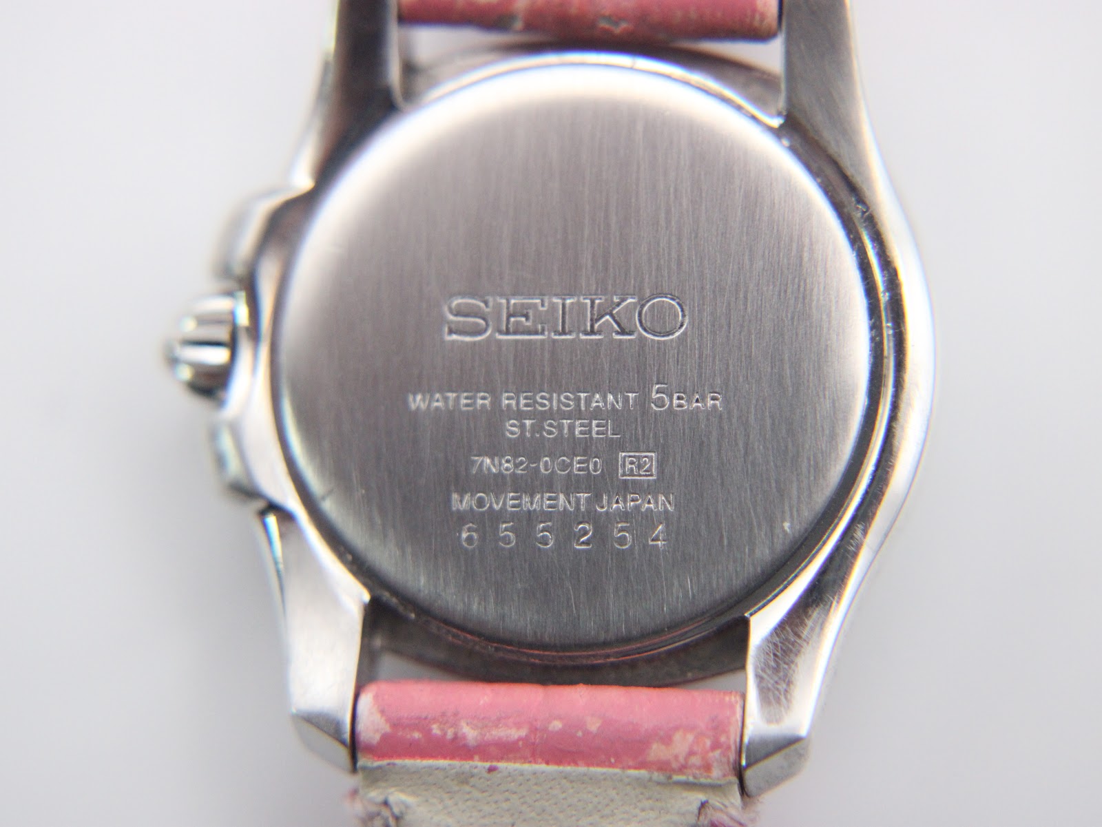 Close-up of the Seiko Vivace watch case back, displaying engraved model number 7N82-0CE0, serial number, and water resistance.