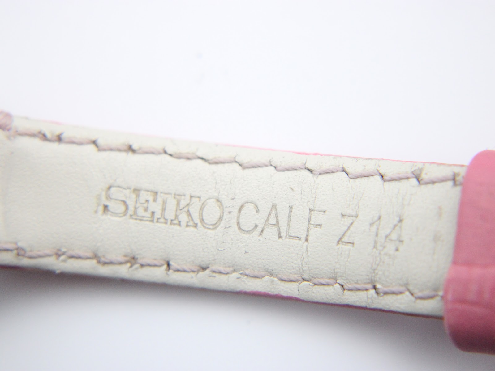 Detailed view of the underside of the pink leather strap, showing the embossed 'SEIKO CALF Z 14' inscription.