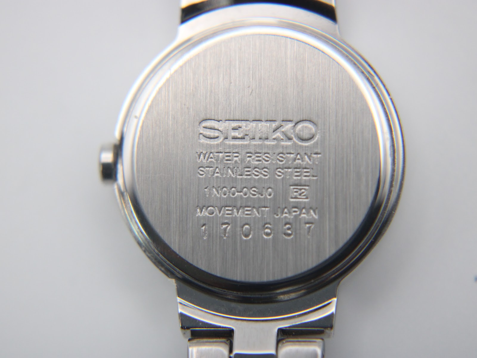 Reverse view of the Seiko watch case back, showing serial number and model details.