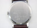 Detail of the dark brown textured leather strap and unbranded buckle.