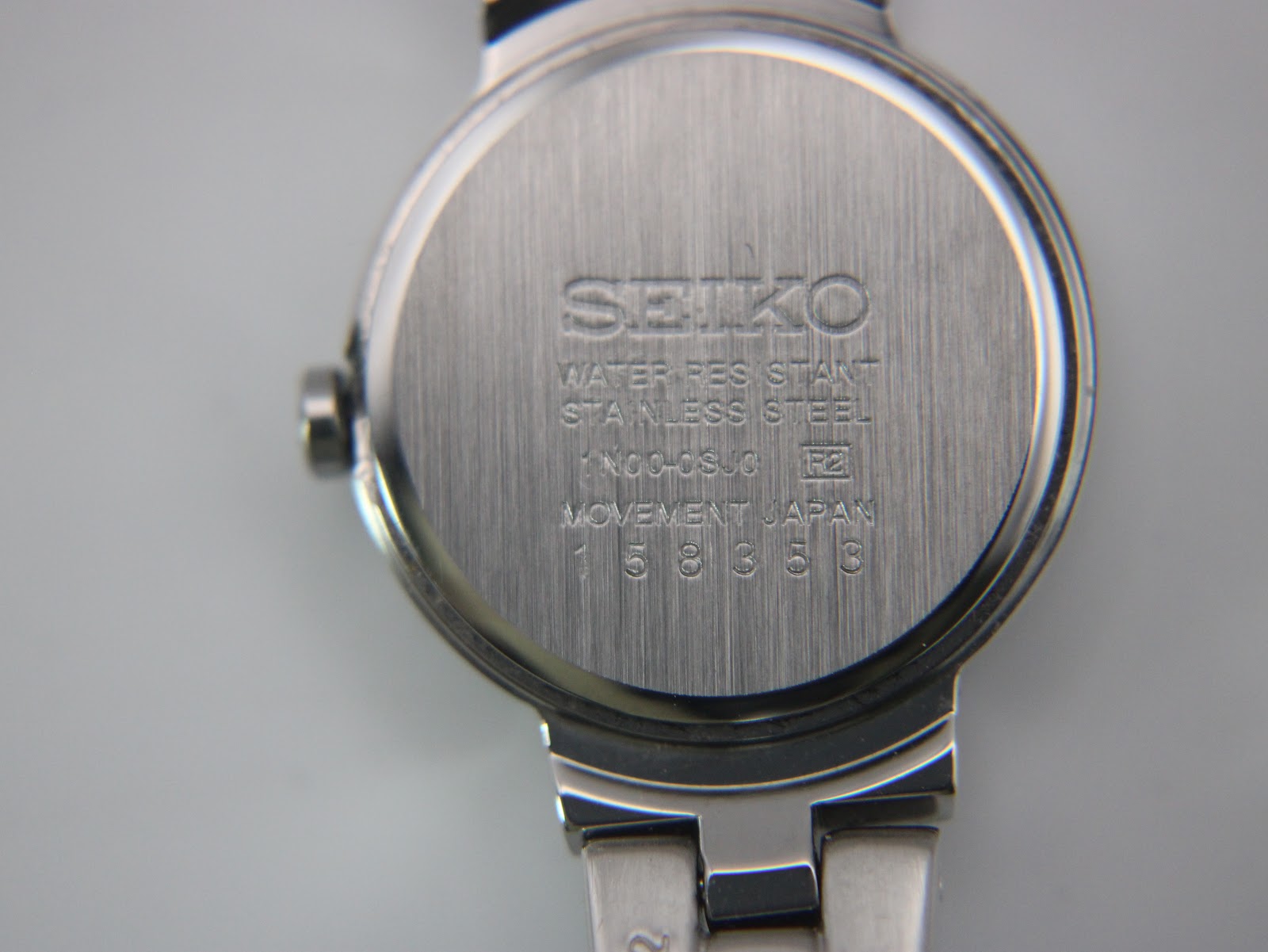 Close-up of the brushed stainless steel case back with Seiko branding and model/serial numbers.