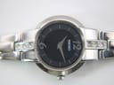 Detailed close-up of the black dial with silver-tone numerals at 12 and 6, baton indices, and Seiko logo.