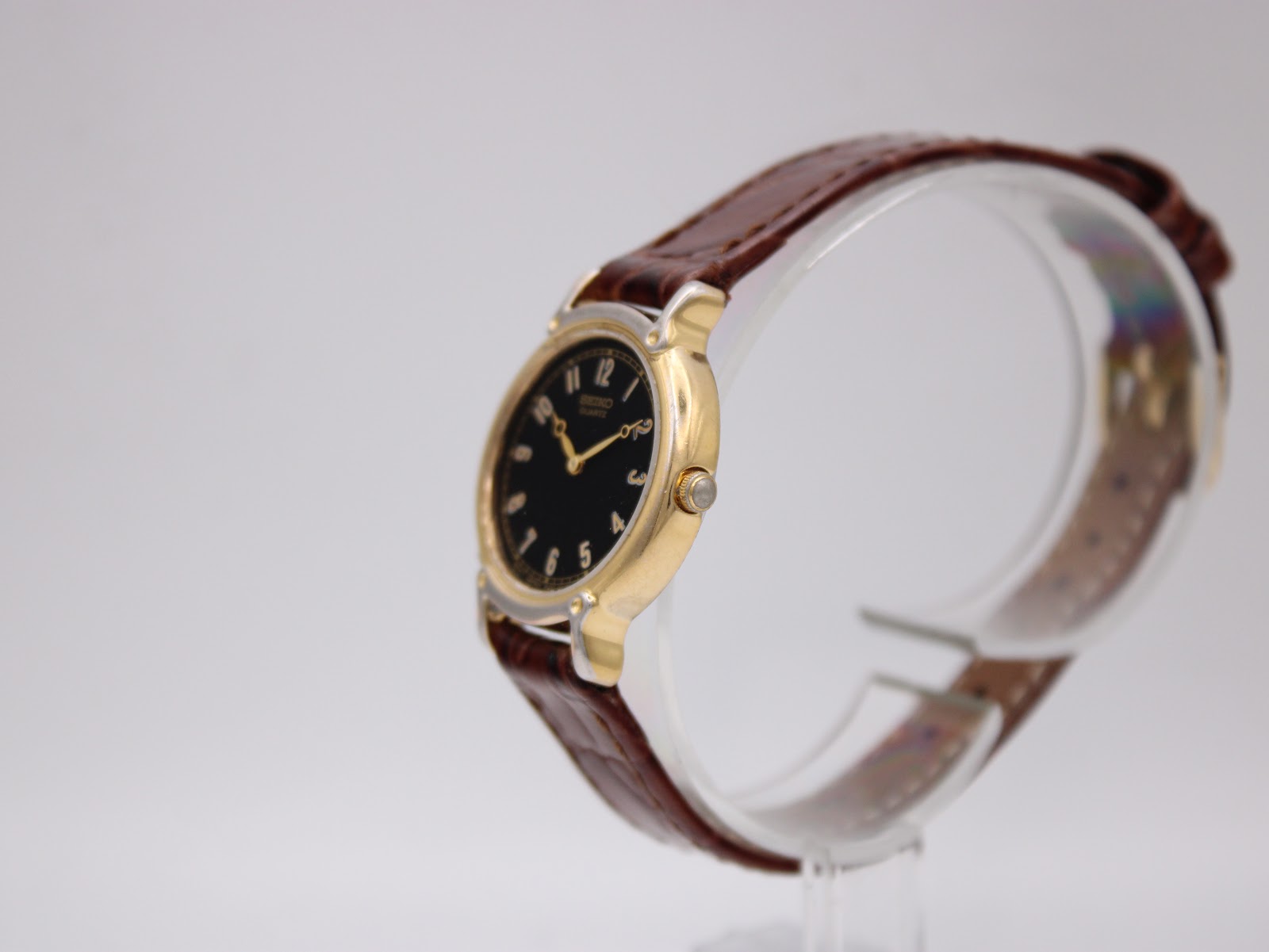 Side profile of the vintage Seiko quartz watch, highlighting the gold-tone case curve and crown.