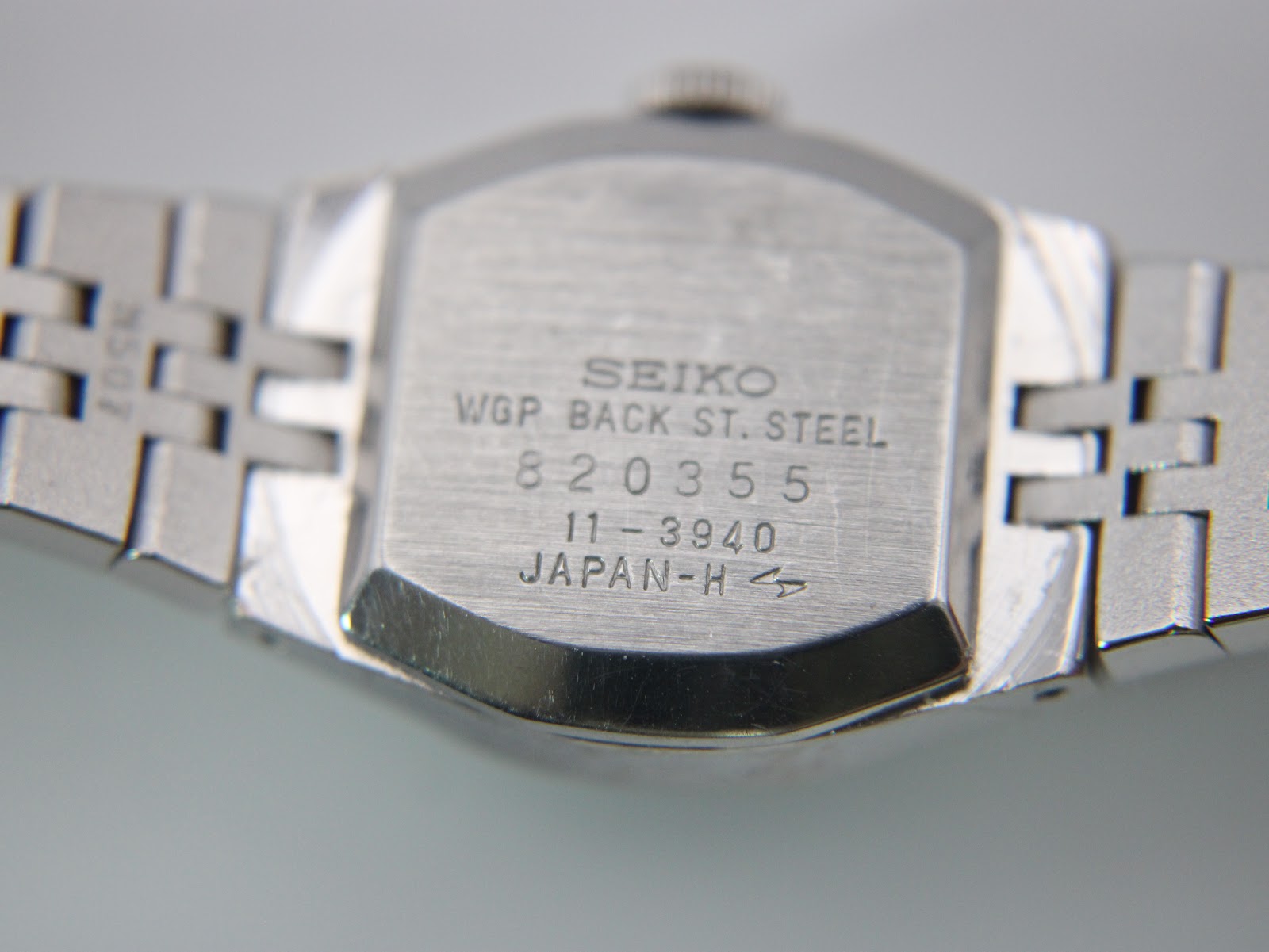 Close-up of the Seiko 11-3940 case back, showing 'WGP BACK ST. STEEL', serial number 820355, model 11-3940, and 'JAPAN-H'.