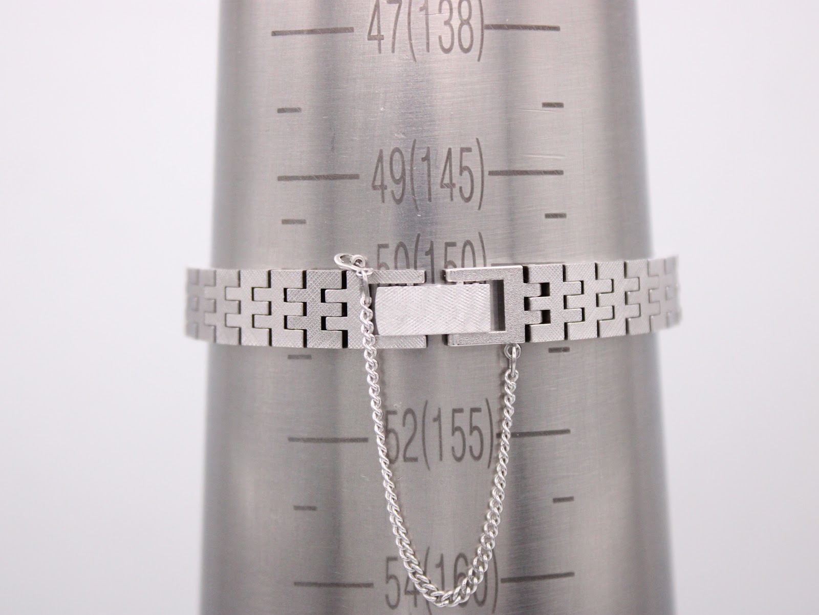 Close-up of the Seiko 11-3940's steel bracelet clasp on a wrist sizing cone, showing a wrist size of 150mm.