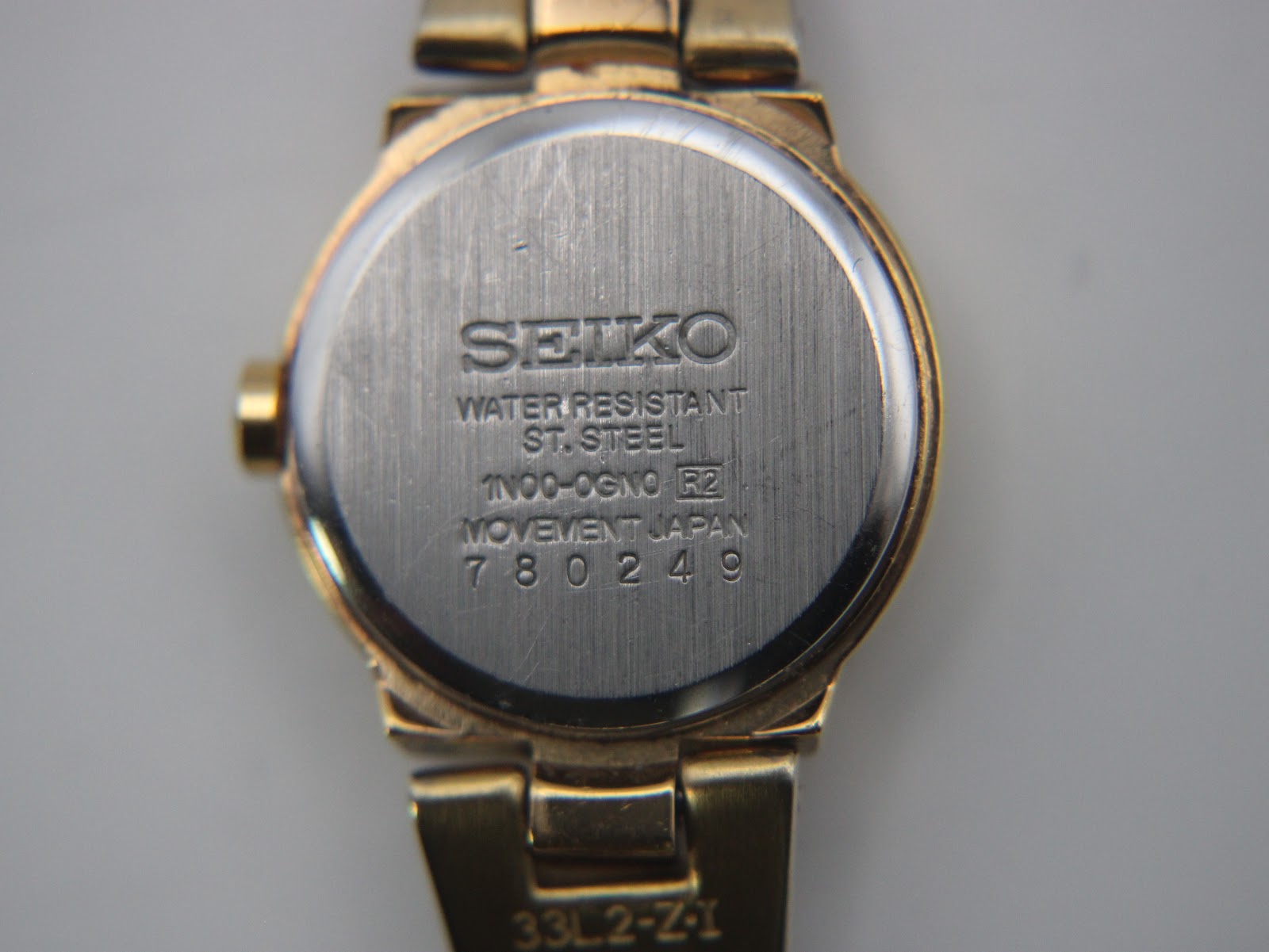 Close-up of the stainless steel case back, showing Seiko branding, model number 1N00-0GN0, serial number, and 'water resistant' text.