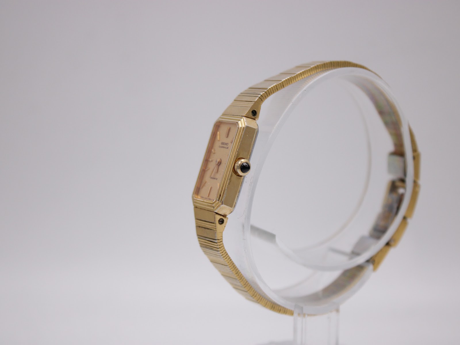 Side view of the Seiko Lassale watch, showing the elegant profile of the gold-tone case and the black cabochon crown.
