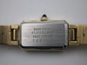 Close-up of the watch case back, revealing engravings 'BASE METAL', 'ST. STEEL BACK', model '1320-5609 R', and serial number '140180'.