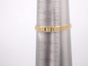 Close-up of the gold-tone expandable bracelet on a wrist sizing cone, showing the bracelet size is approximately 155mm / 15.5cm.