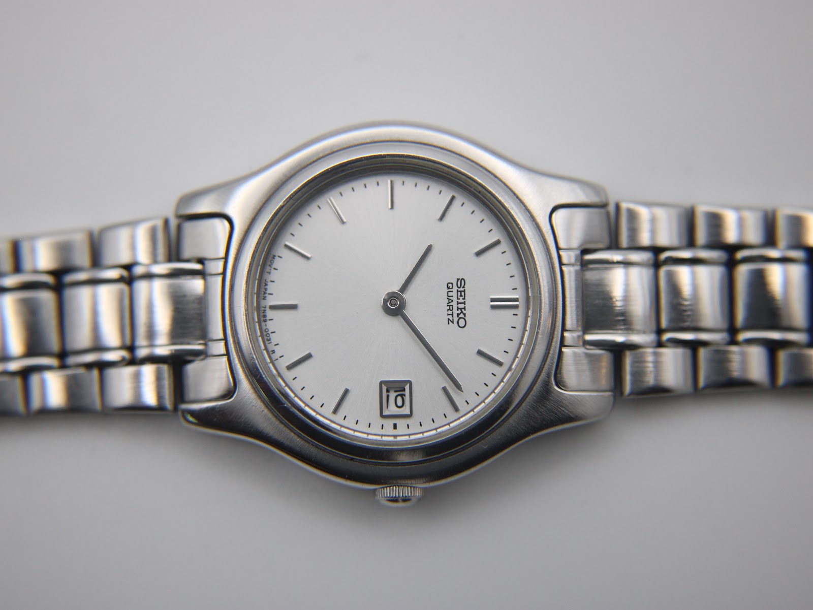 Integrated stainless steel bracelet of the Seiko 7N89-0021 watch on a sizing cone.