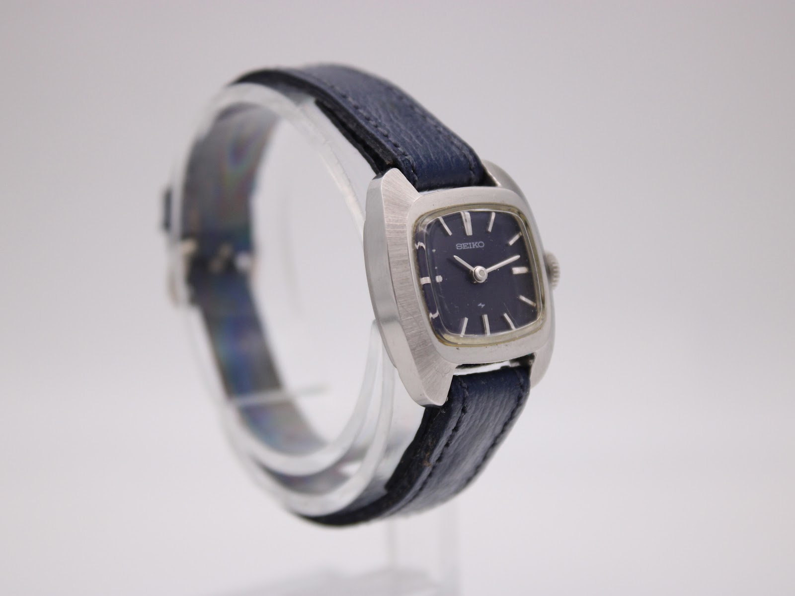 Close-up of the watch's navy blue textured leather strap and classic silver-tone buckle.