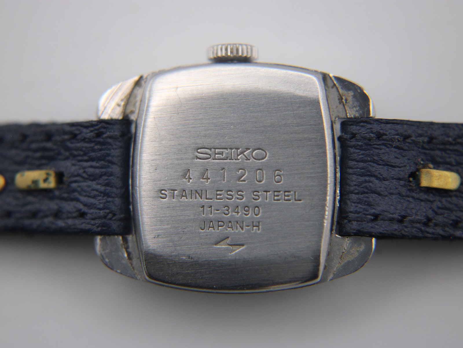 Detail shot of the navy blue dial with applied silver baton indices and Seiko logo.