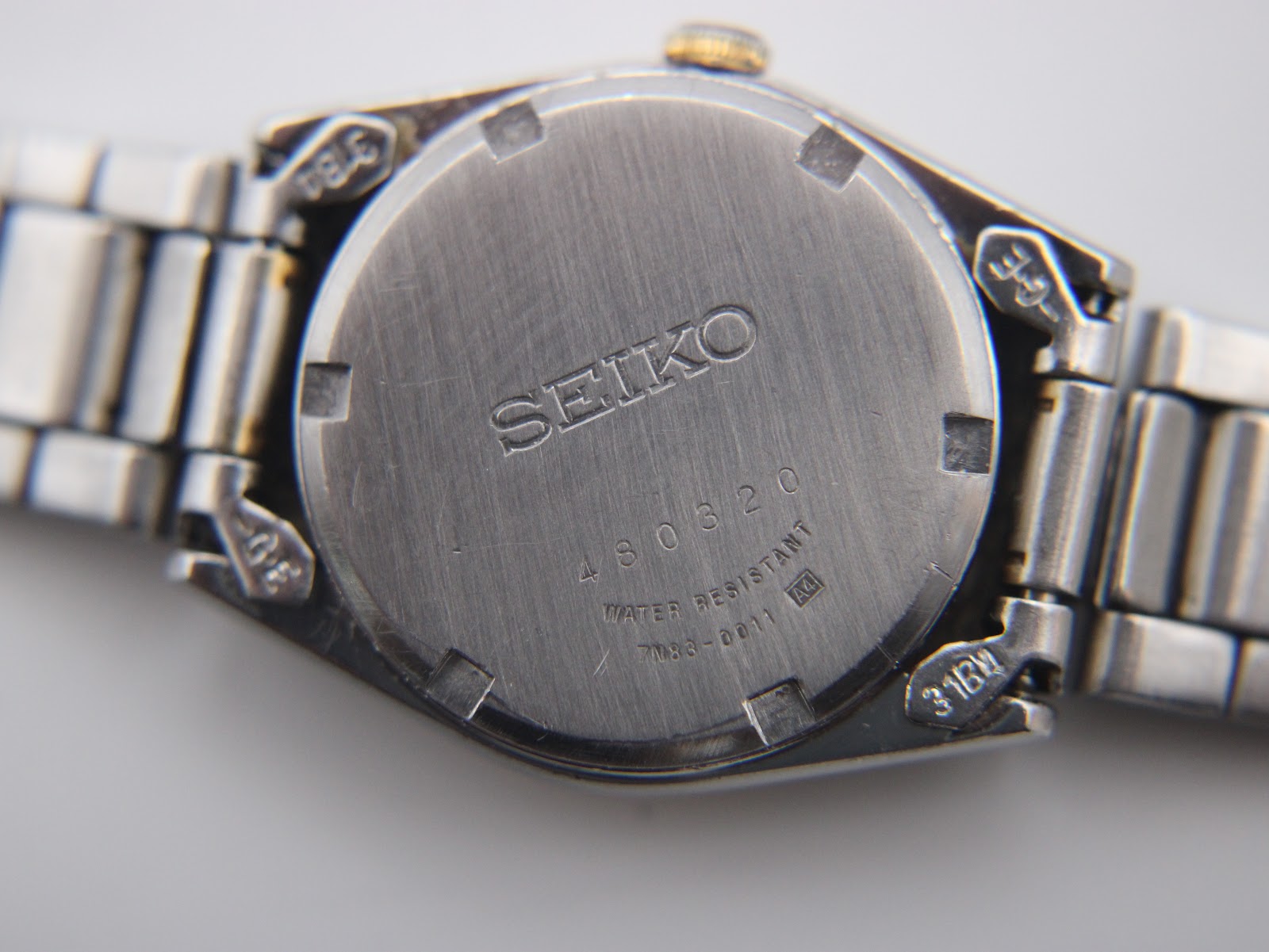 Case back of Seiko 7N83-0011 watch showing serial number, model, and 'WATER RESISTANT'.