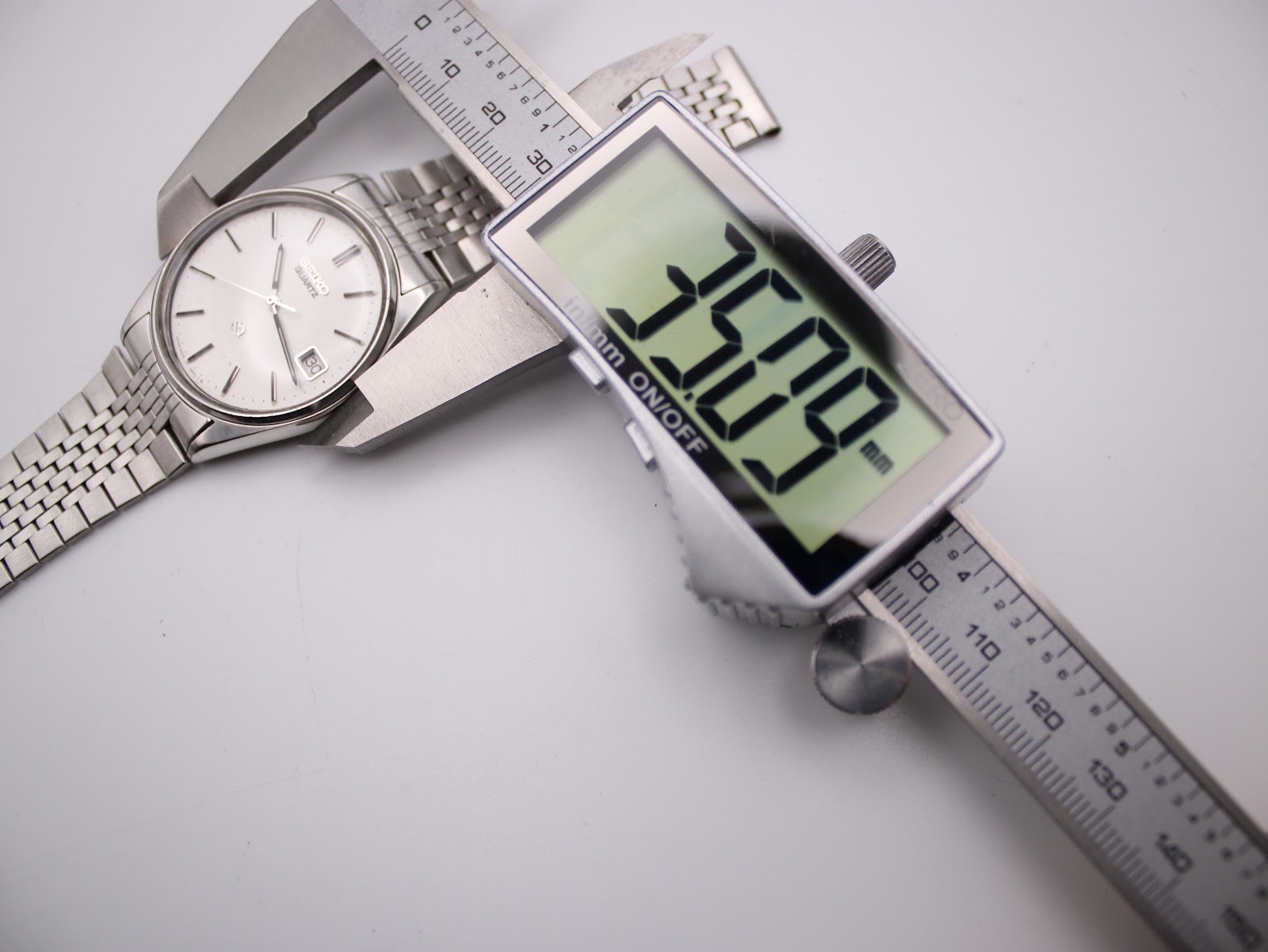 Digital caliper measuring the case diameter of the Seiko watch, displaying a precise measurement of 35.09mm.