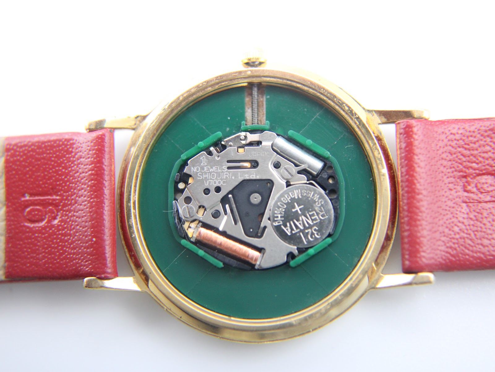 Close-up view of the Seiko V700C quartz movement inside the watch, showing the battery and internal components.