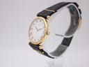 Right side profile view of the Seiko watch, highlighting the slim gold-plated hexagonal case and crown on a clear watch stand.