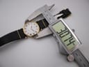 Overhead view of the watch on its strap, with a digital caliper measuring the case diameter at precisely 30.74mm.
