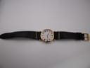 Full overhead view of the Seiko watch with its black lizard-grain leather strap and gold-tone tang buckle laid flat.