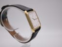 Close-up of the watch's black leather strap with crocodile pattern and gold-tone buckle.