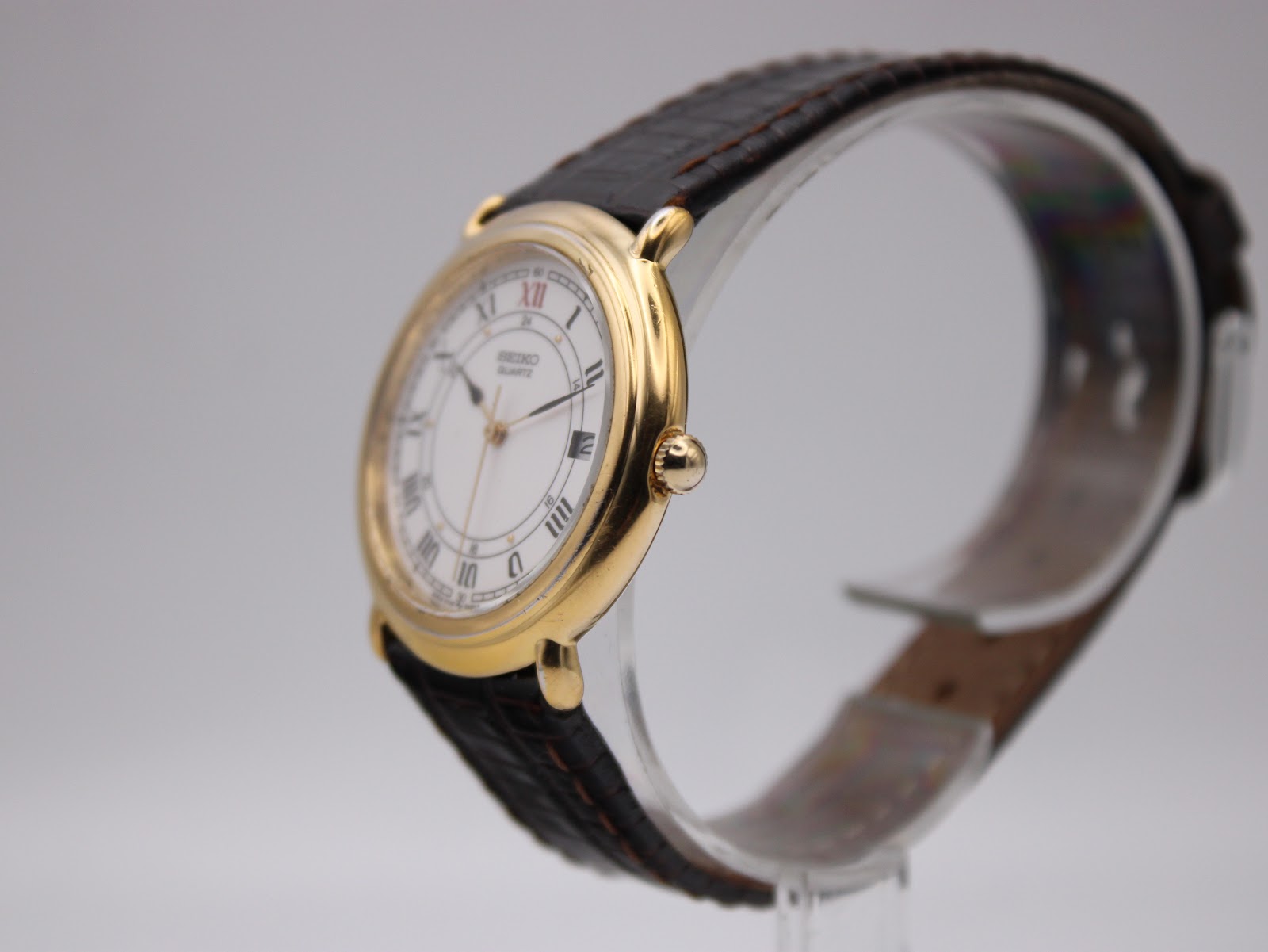 Angled side view of the Seiko watch, highlighting the elegant gold-tone case and profile of the strap.