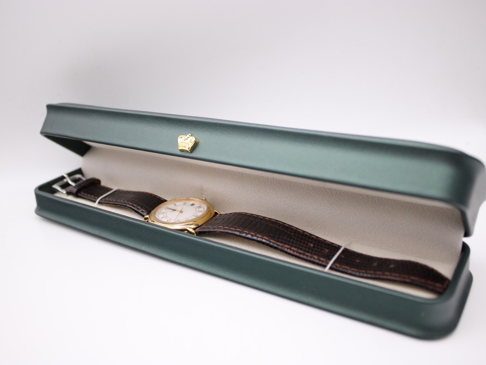 The Seiko watch lying in a generic green watch presentation box, showcasing its full length.