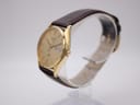 Angled side view of the Seiko watch, showing the profile of the gold plated case and the crown.