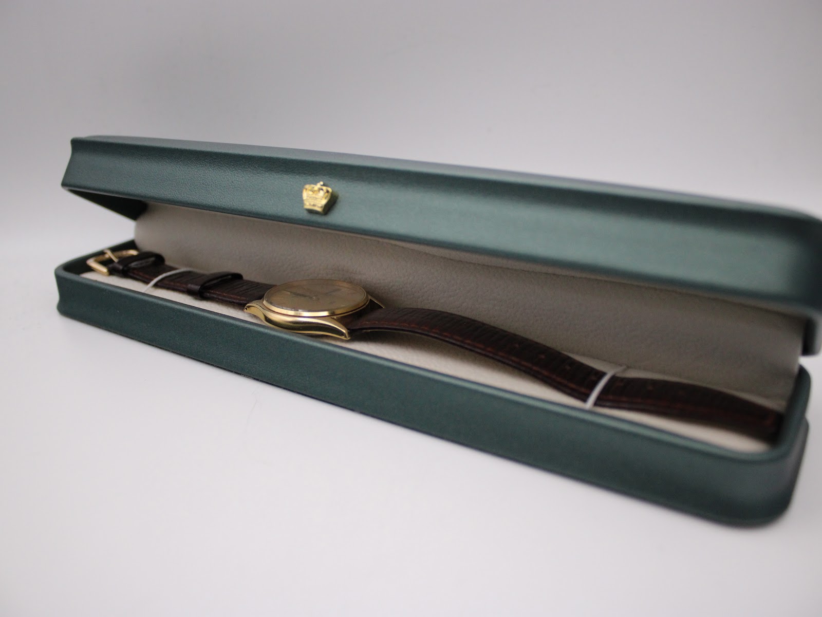 The Seiko watch displayed in a green, non-original presentation box with a crown emblem.