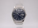 Front view of the Seiko 7123-8430 watch with a striking navy blue dial and stainless steel bracelet against a plain white background.