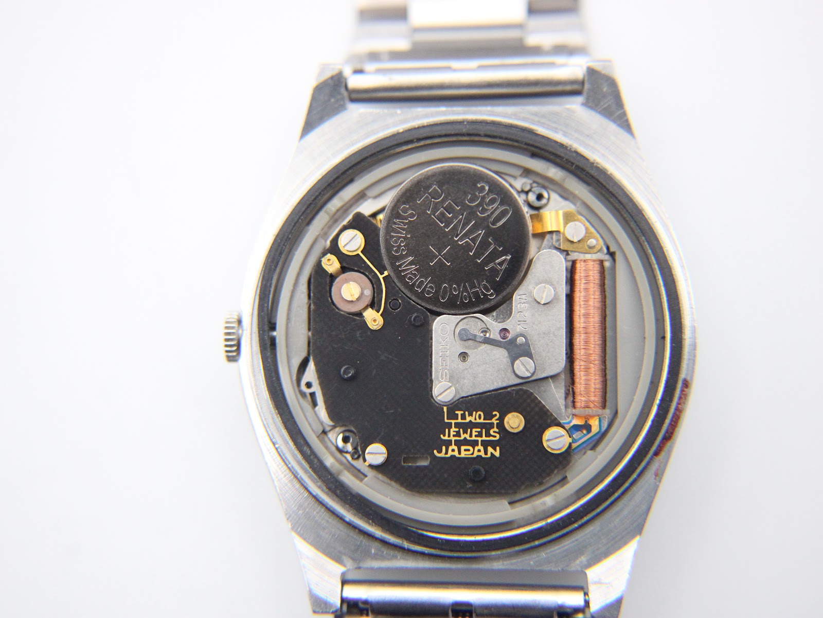 Interior view of the watch showing the Seiko 7123 quartz movement with a Renata 390 battery installed, revealing 'Two Jewels Japan' text.