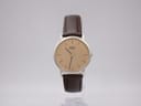 Front view of a Seiko 7800-7009 quartz watch with a gold dial and dark brown leather strap.