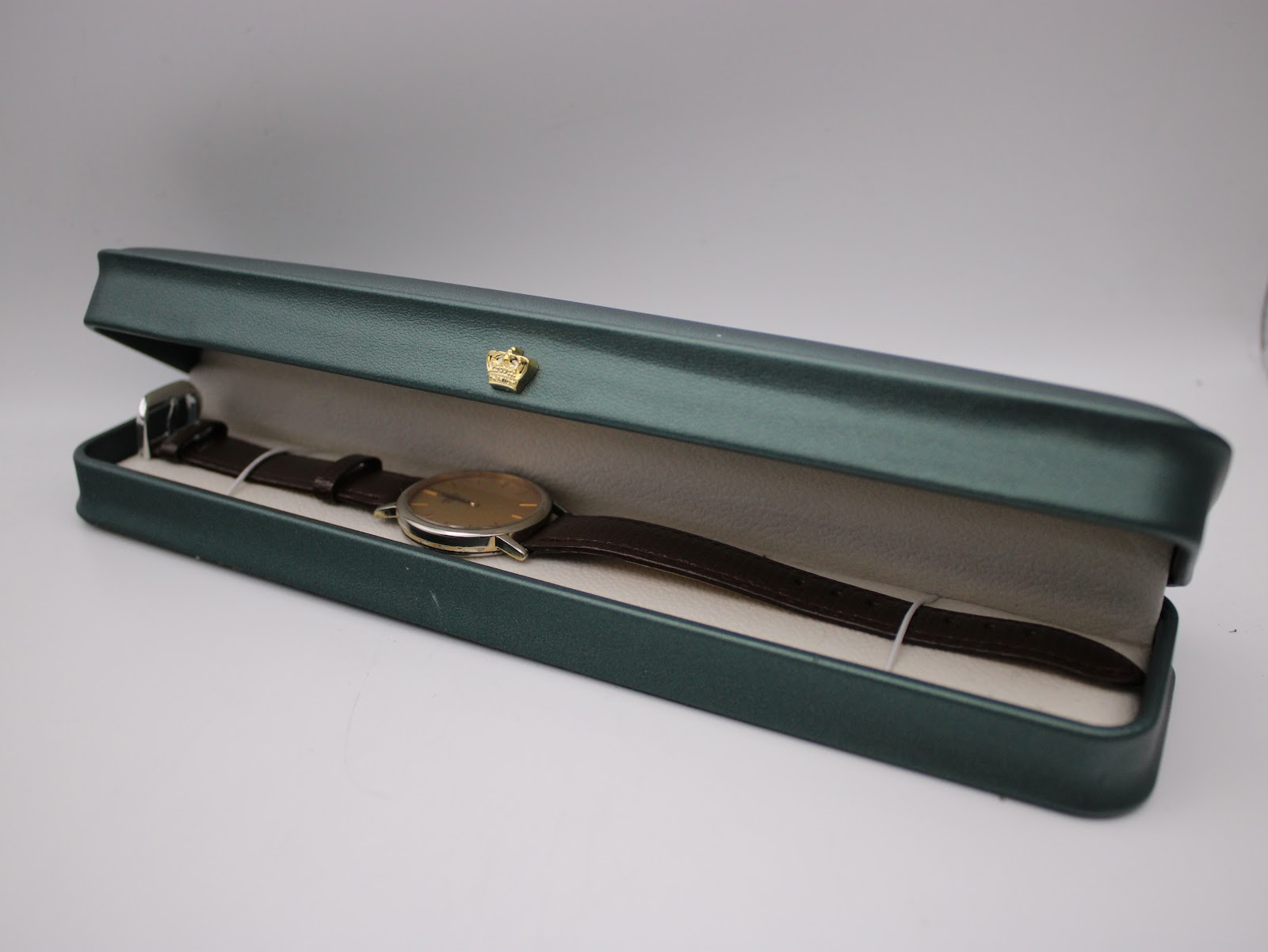The Seiko 7800-7009 watch resting inside a generic long green presentation box.