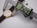 Digital caliper measuring the watch case diameter at 35.09mm, with the watch body visible in the background.
