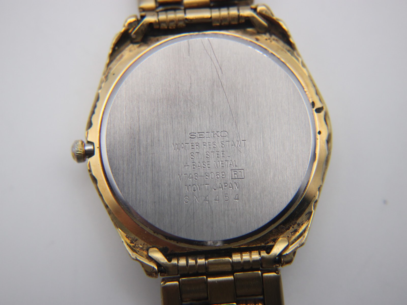 Close-up of the stainless steel case back, showing Seiko branding, model number V743-8069, and serial number 8N4454.