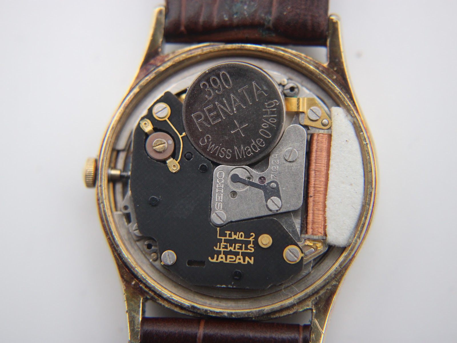 Macro shot of the Seiko 7122A quartz movement visible inside the opened case, with a Renata 390 battery.