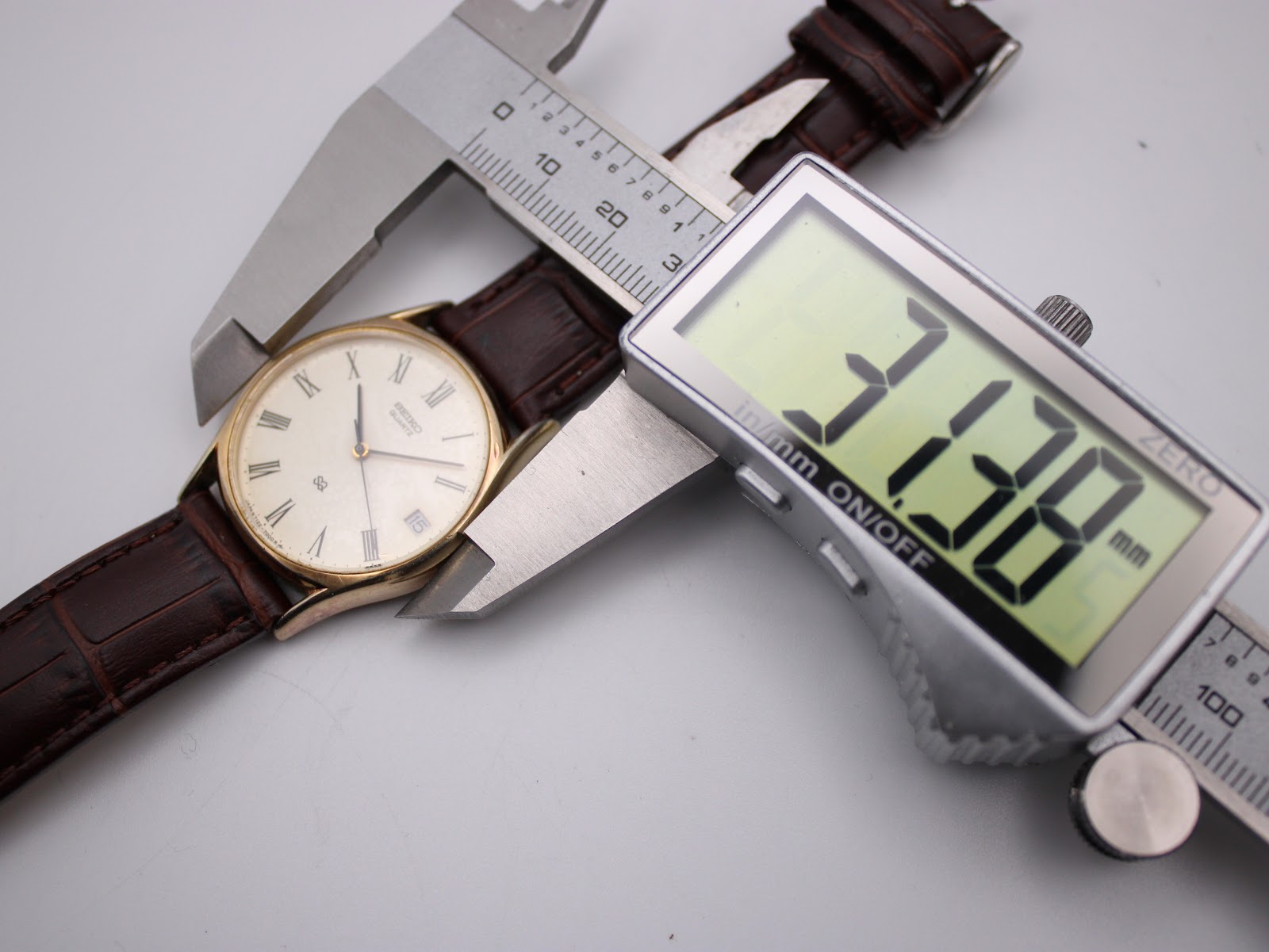 Digital caliper measuring the case diameter of the Seiko watch, displaying a precise measurement of 31.78mm.