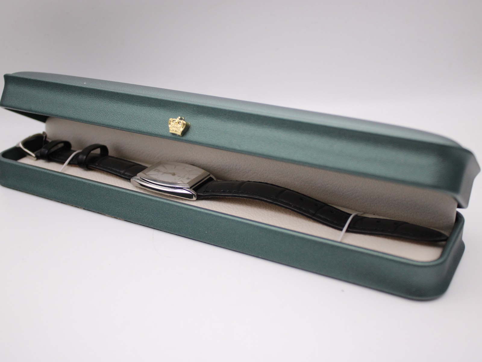 The Orient UNBH-CO watch displayed inside a green watch presentation box.